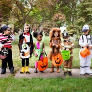 Children in Halloween fancy dress costumes knock on neighbourhood doors and say Trick or treat?
