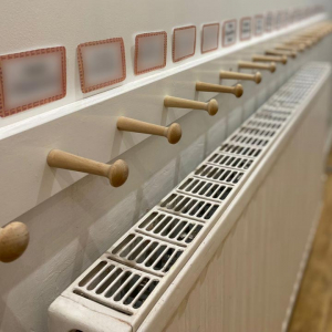 Some coat pegs, suitably named (obscured for privacy) for each child. Some coat pegs, suitably named (obscured for privacy) for each child.